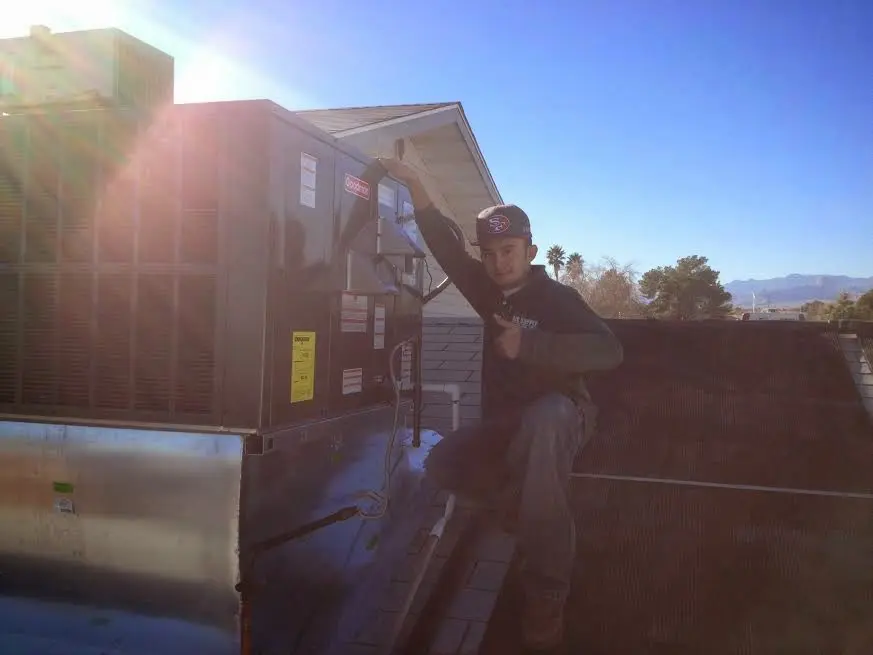 HVAC technician performing Heat Pump Repair on a rooftop unit in Josephine